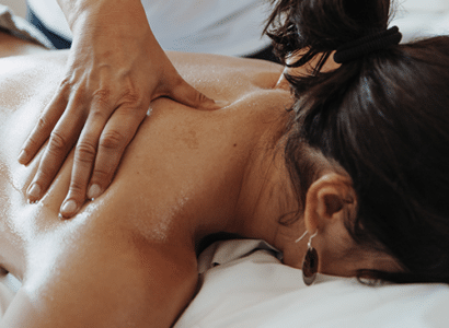 Eine Frau erhaelt eine entspannende Nackenmassage.