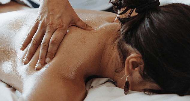 Frau wird im Nacken und an der Schulter massiert bei einer Massage in der Therme Wien.