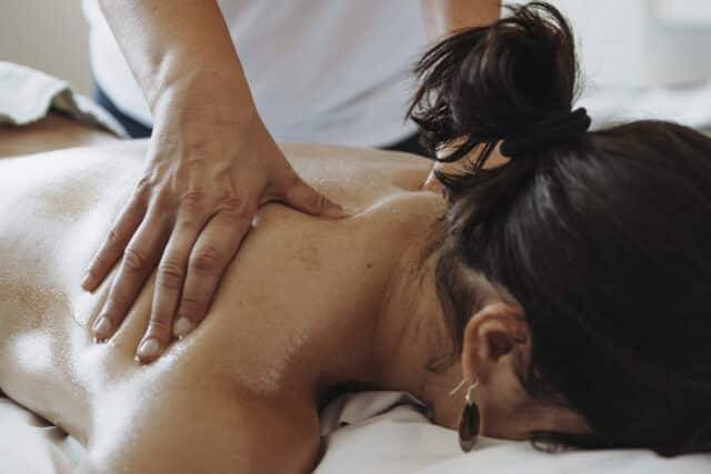 Frau wird bei der Nacken und Schulter Massage Therme Wien von einem Masseur massiert.