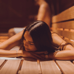Junge Frau liegt in der gemischten Sauna der Therme Wien