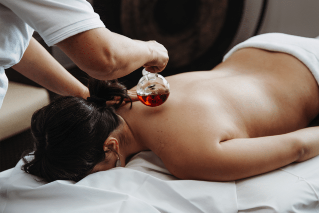 Frau wird bei aroma oel massage 25 minuten mit Oel uebergossen