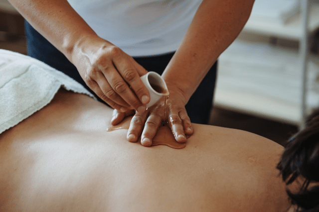 Massageoel wird auf ruecken von Kundin verteilt bei detoxing 25 und 50 massage