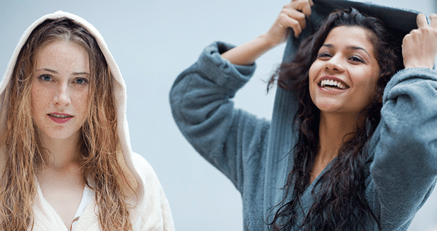 Zwei junge Frauen in Bademaenteln laecheln in die Kamera waehrend sie wellnessen.